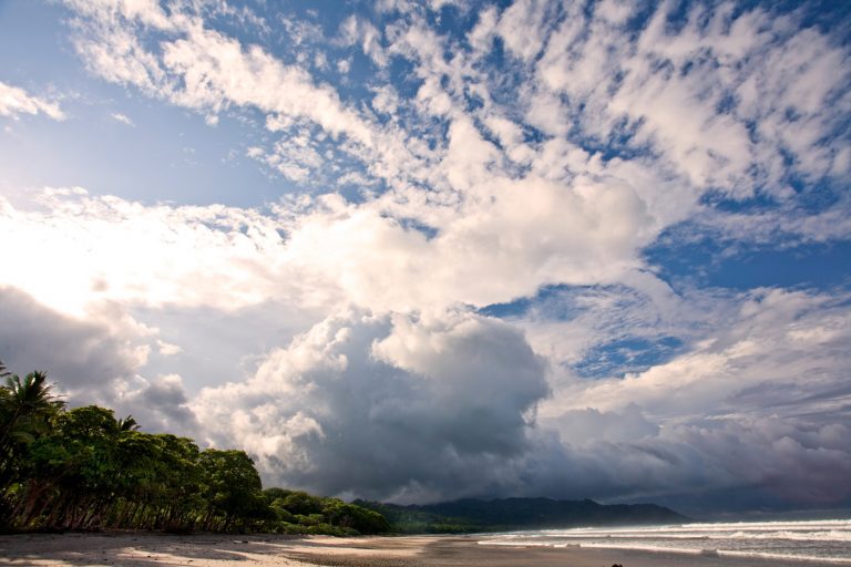 The beach in Costa Rica with a big sky with lots of fluffy clouds